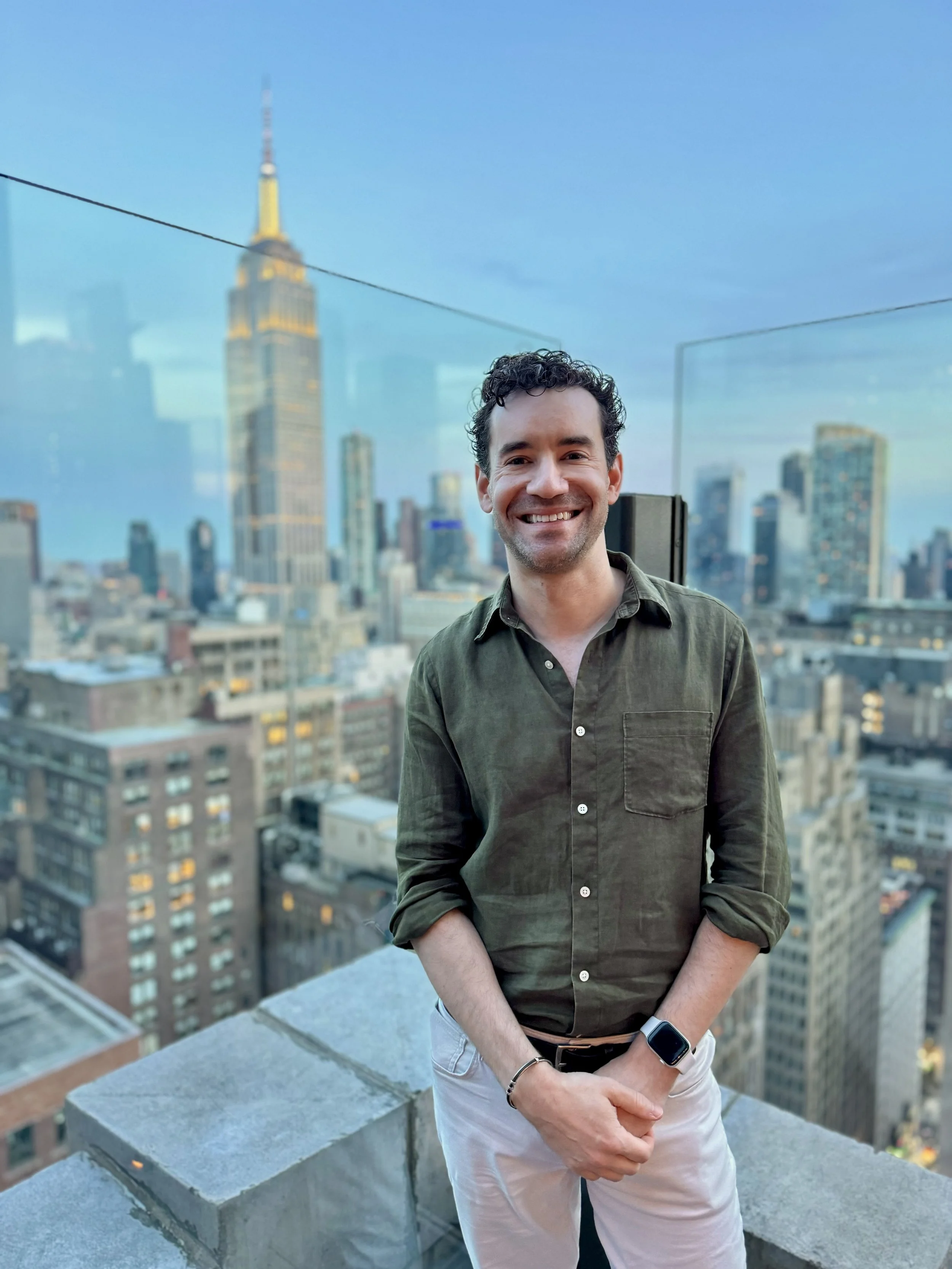 David Polk on a New York rooftop with the Empire State Building behind him